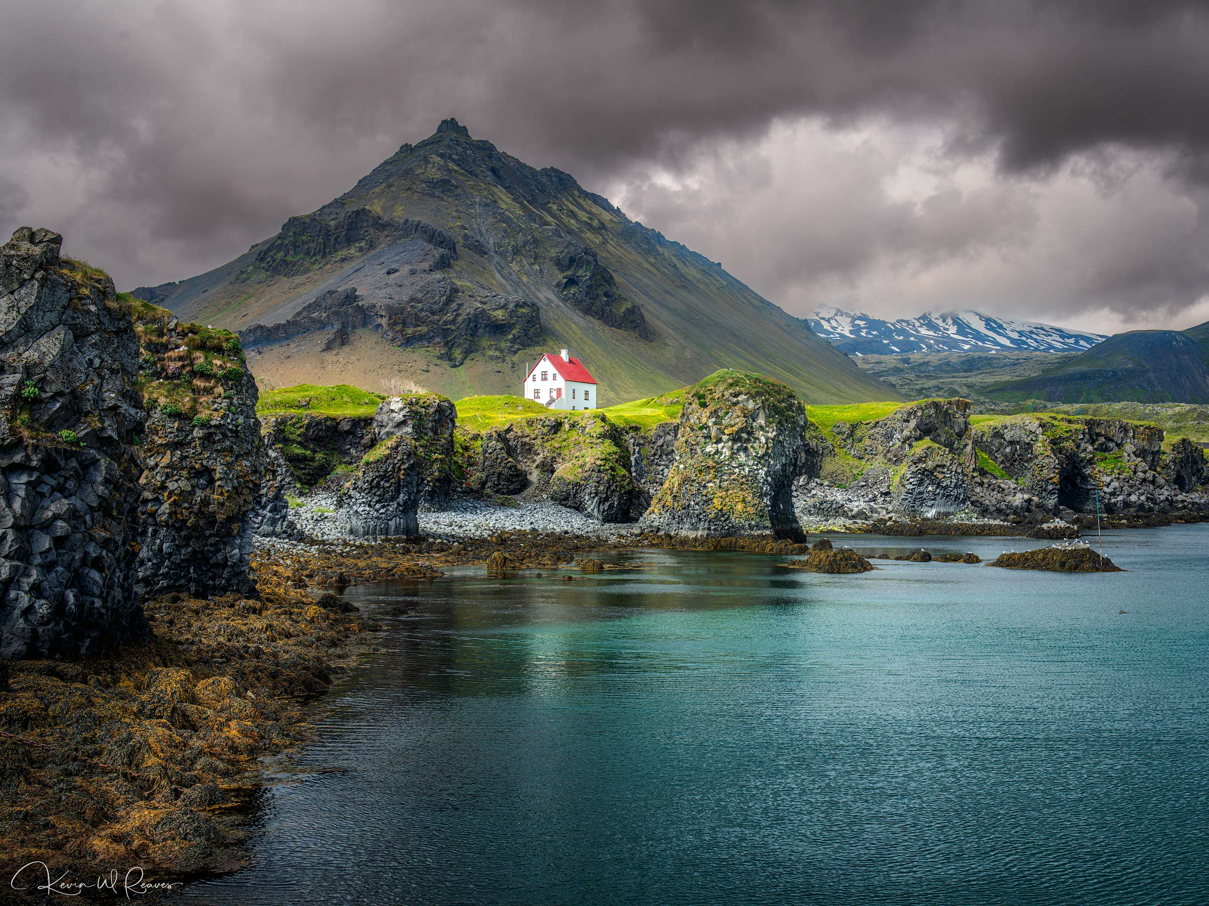 A Light in the Storm Along Iceland's rugged Snæfellsnes Peninsula, the small village of Arnarstapi rests between towering volcanic peaks and...