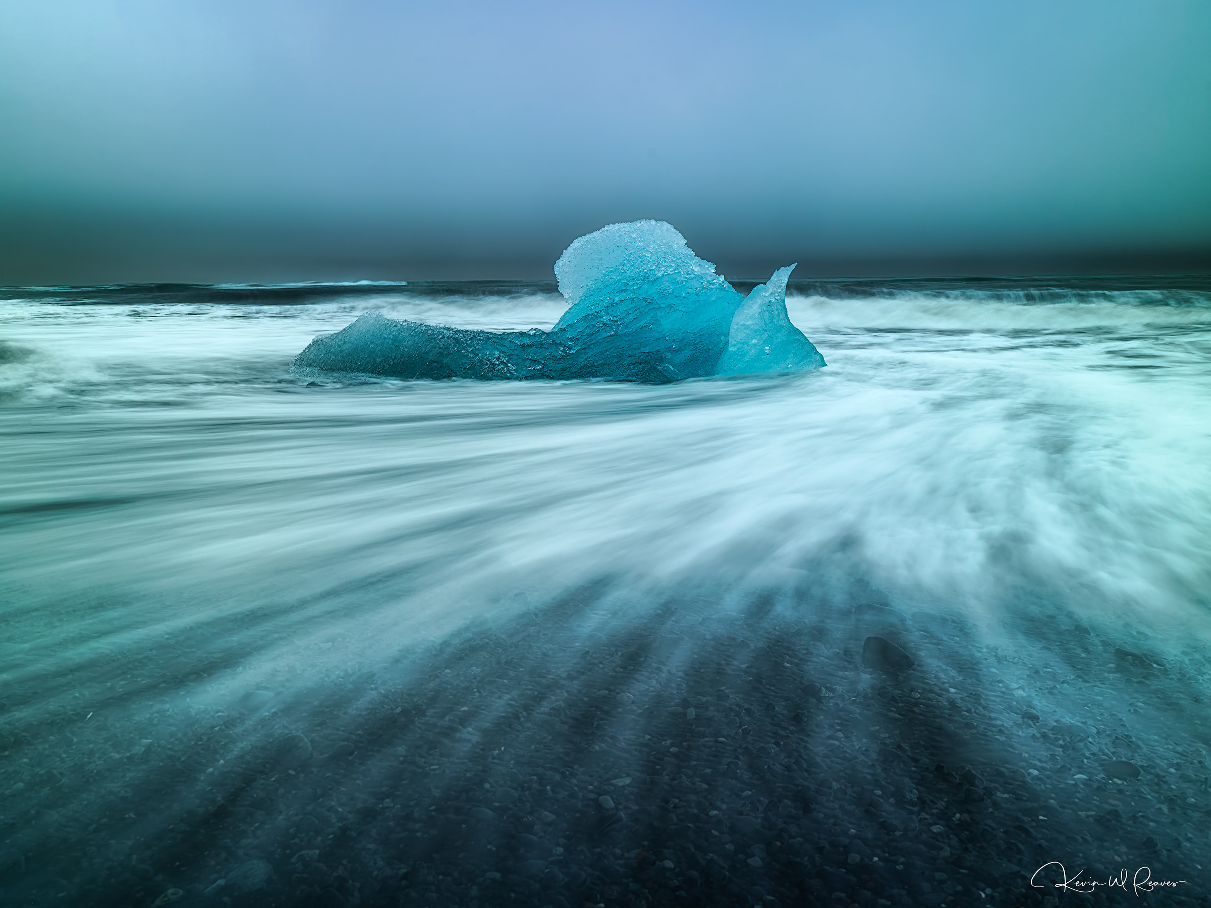 Tides of Eternity A brilliant fragment of ancient glacial ice rests upon the black volcanic sands of Diamond Beach, where the relentless North...
