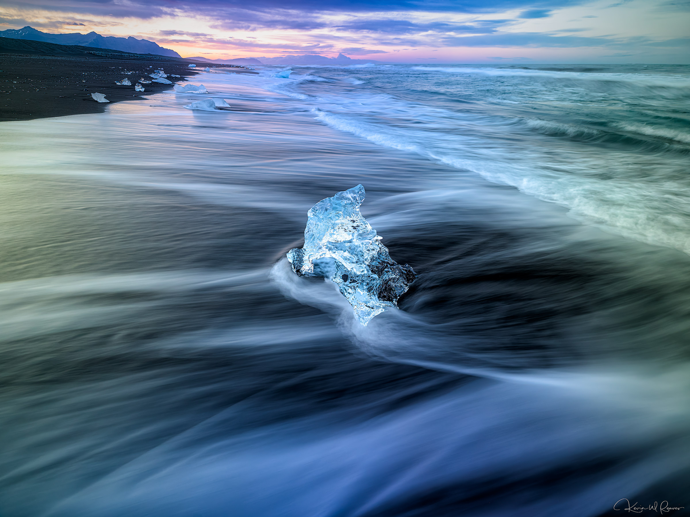 Time Adrift A solitary fragment of ancient glacial ice rests momentarily on the black volcanic sands of Diamond Beach as silky waves swirl...